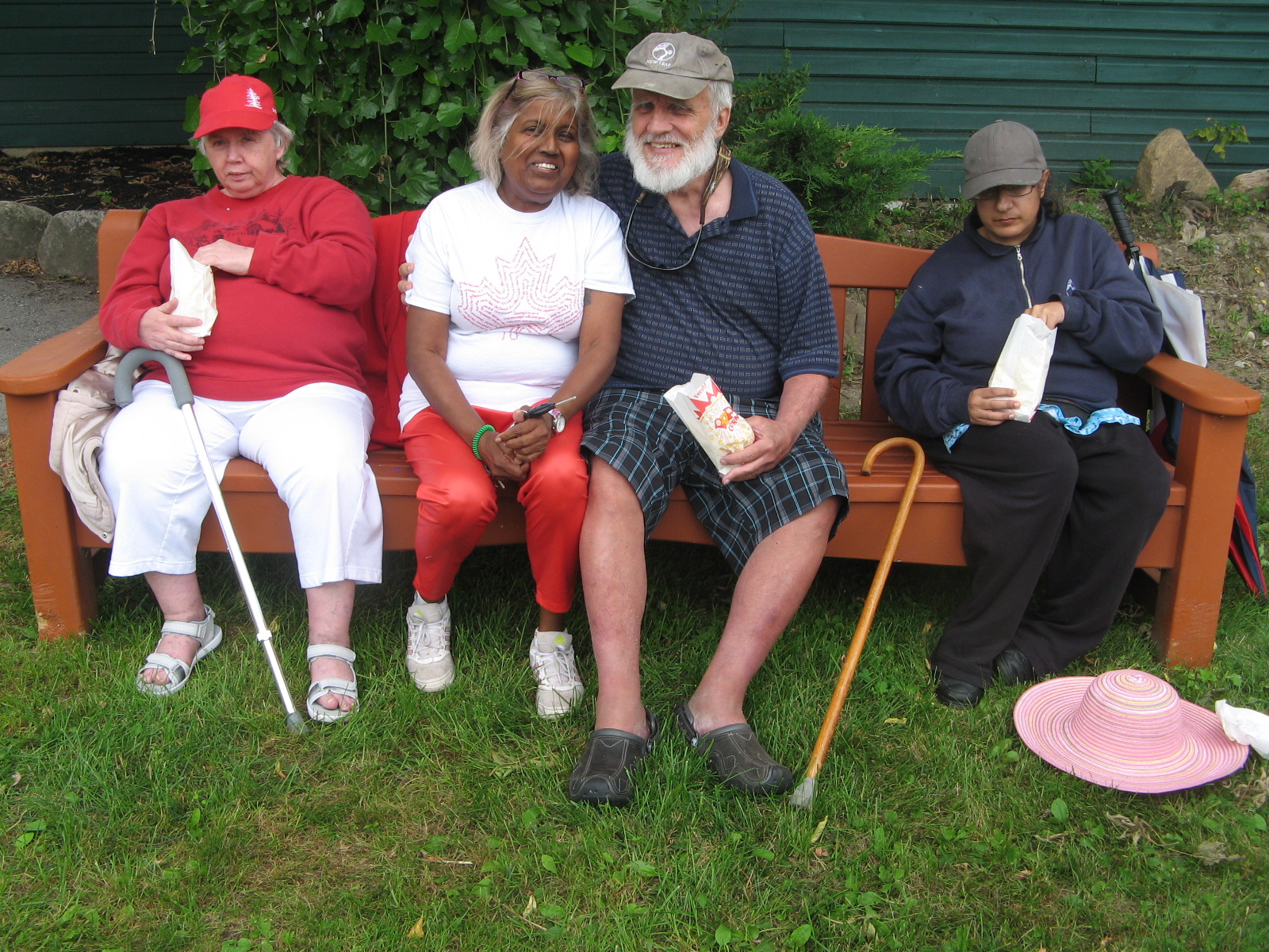 Four residents sitting on a bench eating popcorn